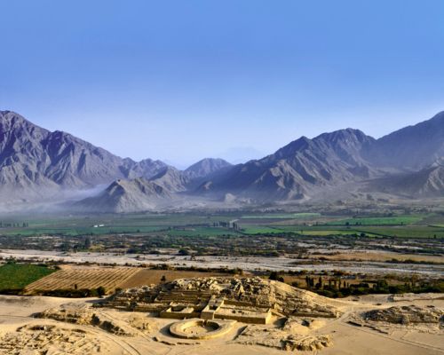 Aerial view of Caral's sacred pyramids framed by the Andes