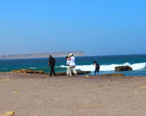 Visitors walking along the Pacific shoreline in the Paracas Reserve