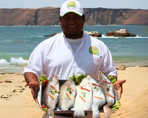 Fisherman holding a tray of fresh fish at the Paracas coastline