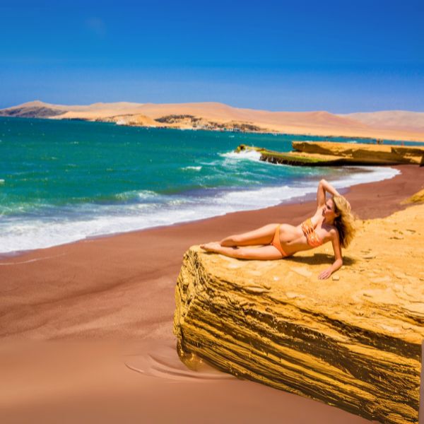 Woman relaxing on a rocky formation at Red Beach in the Paracas Reserve