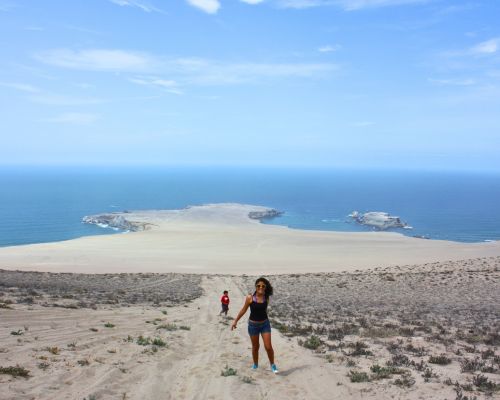 Hikers descending toward San Fernando Bay with the Pacific Ocean in the background