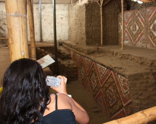 Tourist photographing murals inside the Moche Temples.