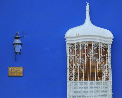 Traditional white colonial balcony on blue wall