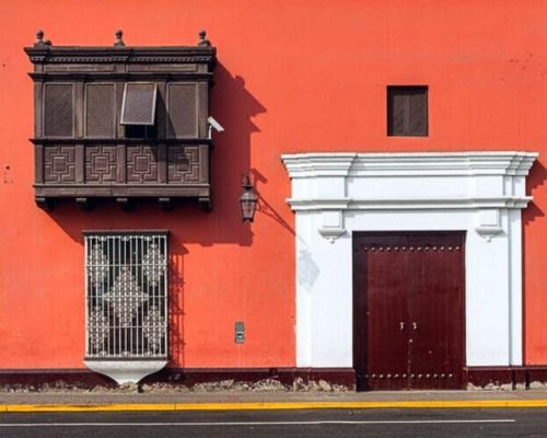 Red colonial house with wooden balcony in Trujillo