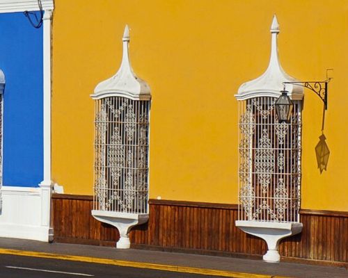 Yellow and blue colonial buildings with white balconies